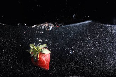 Su olgun tatlı çileğin üzerine damlıyor. Metnin için kopyalama alanı olan taze böğürtlen arka planı. Vegan kavramı.