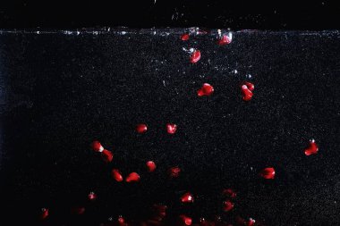 Olgun tatlı nar tohumlarına su damlaları düşer. Metnin için kopyalama alanı olan taze nar arkaplanı. Vejetaryen ve vejetaryen kavramı.