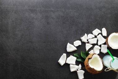 Hindistan cevizi koyu taş bir masada. Hindistan cevizi yağı ve cips.