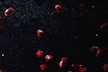 Olgun tatlı nar tohumlarına su damlaları düşer. Metnin için kopyalama alanı olan taze nar arkaplanı. Vejetaryen ve vejetaryen kavramı.