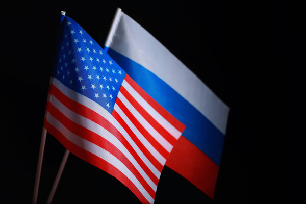 The concept of diplomatic relations. Flag of the United States of America and Russian Federation. Sanctions pressure in politics.