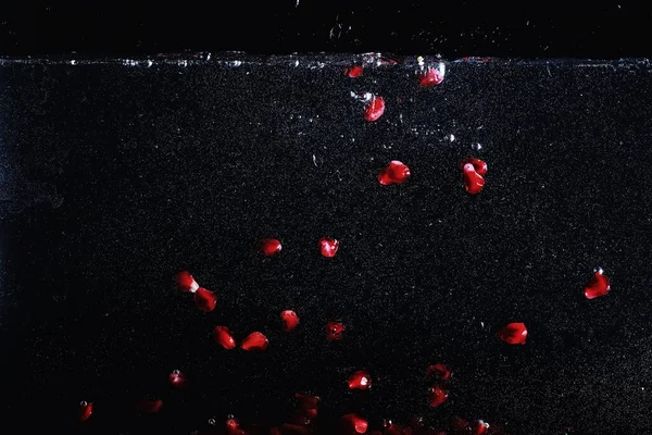 Olgun tatlı nar tohumlarına su damlaları düşer. Metnin için kopyalama alanı olan taze nar arkaplanı. Vejetaryen ve vejetaryen kavramı.