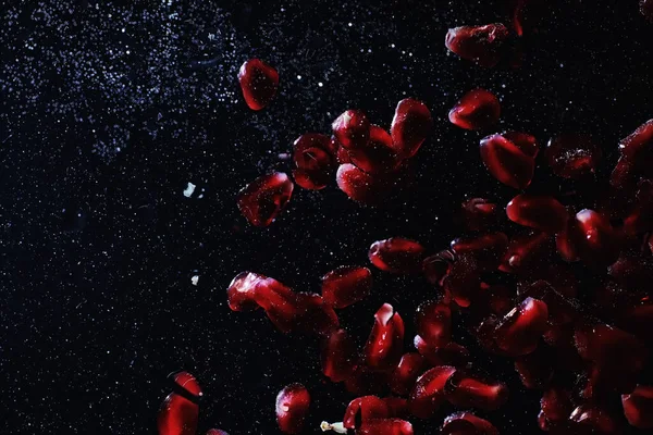 Olgun tatlı nar tohumlarına su damlaları düşer. Metnin için kopyalama alanı olan taze nar arkaplanı. Vejetaryen ve vejetaryen kavramı.