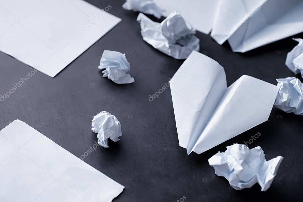 Paper airplane on the table. Origami model on a dark background. Concept. Creative waste time.