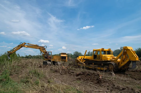 Excavadora y excavadora despejando tierras forestales . — Foto de Stock