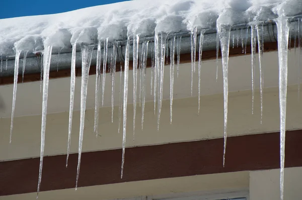 Gefährliche Eiszapfen. Bußgelder für Schnee und Eis auf Dächern. — Stockfoto