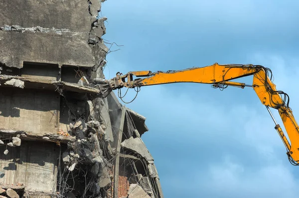 Removing a reinforced concrete building in an urban area with a excavator Stock Picture