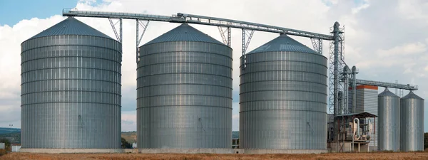 Silos. Almacenamiento y secado de granos, trigo, maíz, soja, girasol contra el cielo azul. Panorama . — Foto de Stock