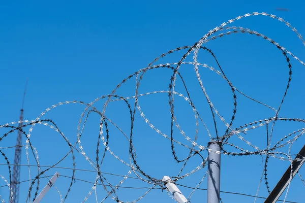 Barbed wire against the blue sky.