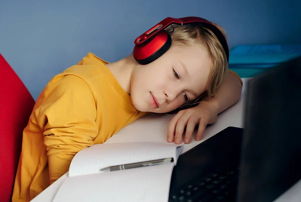 child learns online. Distance education. Boy tired after school