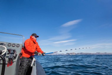 bir tekne olta balıkçılık dostum. Kırmızı ceket.