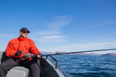 Onun bir iplik çubuk ile güneş gözlüğü takıyor balıkçı atlet 