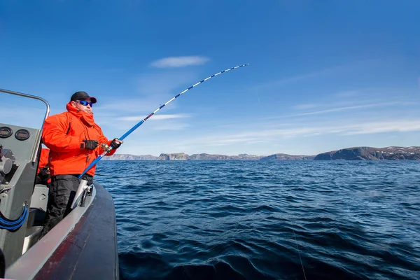 Powerful man with a spinning rod in his hands. sea boat. fisherm — Stock Photo, Image