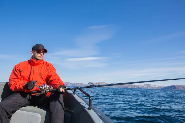 Fischersportler mit Sonnenbrille und Spinnrute in der Hand — Stockfoto