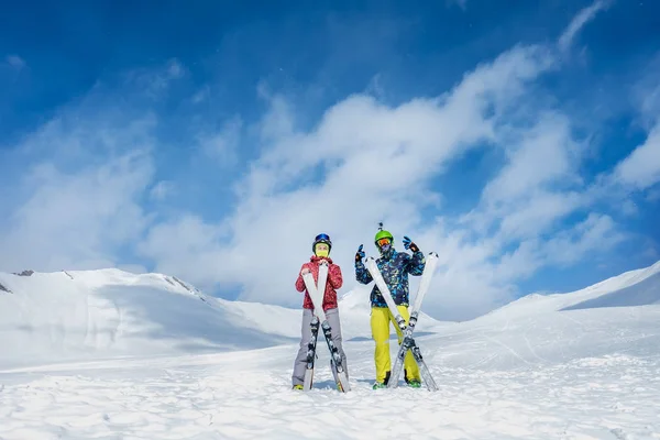 Δύο σκιέρ σταθεί στο παρασκήνιο από χιονισμένα βουνά. ο άνθρωπος και gi — Φωτογραφία Αρχείου