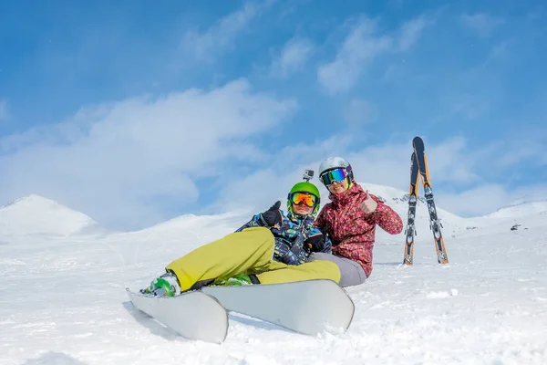 Två skidåkare sitta i snön mot bakgrund av snö äv — Stockfoto