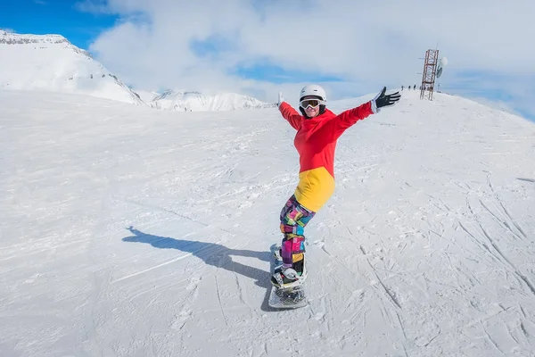 Ung flicka snowboardåkare i rörelse på snowboard i bergen — Stockfoto