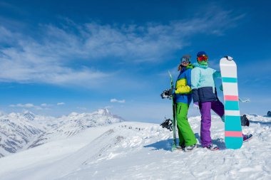 İki kızın snowboard tahtaları düzenliyoruz. Kış. Dağlar