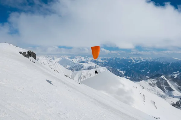 Paraglider flyger över de snötäckta bergen — Stockfoto