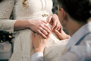 Karın hamile bir kadının ellerinde.