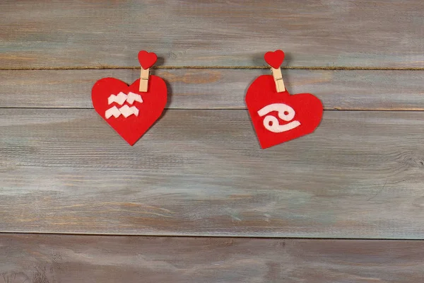 Aquarius and cancer. signs of the zodiac and heart. wooden backg