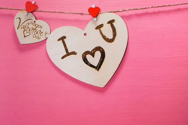 Dos corazones de madera en una cuerda Dos corazones rojos en un tendedero en Vista desde arriba. Concepto de San Valentín. fondo rosa. Espacio de copia para inscripciones . — Foto de Stock