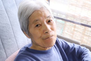 Kıdemli bayan hemşire yatağında oturuyor ve bu tarafa bakıyor.