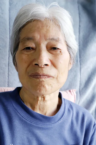 Senior lady sitting on the nursing bed and staring this way — 스톡 사진