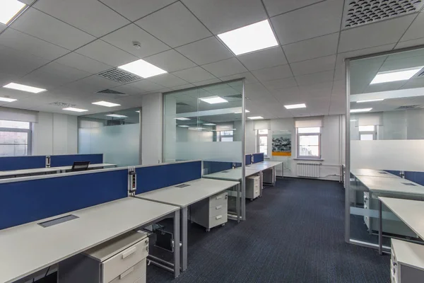 Interior de escritório moderno com várias estações de trabalho em plano aberto em mesas longas — Fotografia de Stock