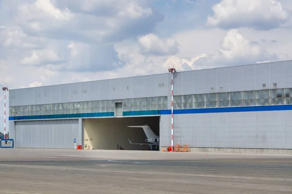 Aircraft hangar door open. Plane tail