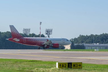 Kırmızı-beyaz uçak taksiye binmek üzere.