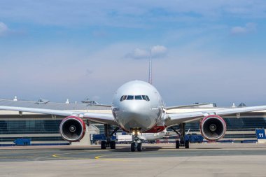 Havaalanının önündeki büyük yolcu uçağının ön görüntüsü. Arka planda havaalanı terminali