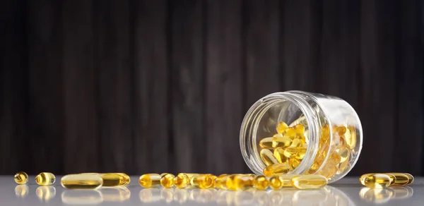 Pills in a jar on wooden background — Stock Photo, Image