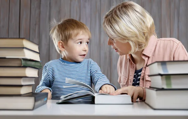 П'ять років дитина читає книгу вдома з матір'ю — стокове фото
