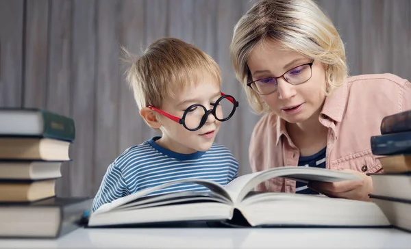 Vijf jaar oud kind dat thuis een boek leest met moeder — Stockfoto