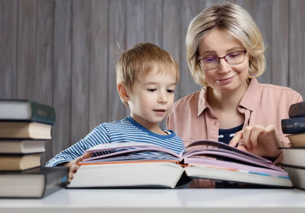 Vijf jaar oud kind dat thuis een boek leest met moeder — Stockfoto