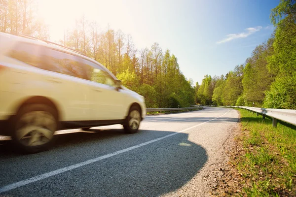 Auto auf Asphaltstraße bei schönem Frühlingstag lizenzfreie Stockfotos