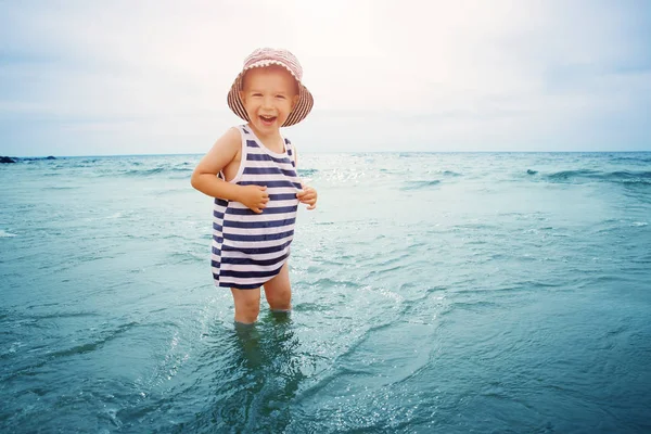 Tre år gammal pojke leker på stranden i vattnet — Stockfoto
