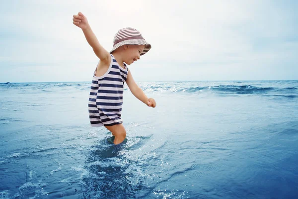 Drie jaar oud jongen spelen op het strand in het water — Stockfoto