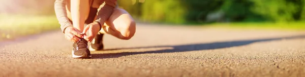 Giovane donna che corre nel parco su strada asfaltata — Foto Stock