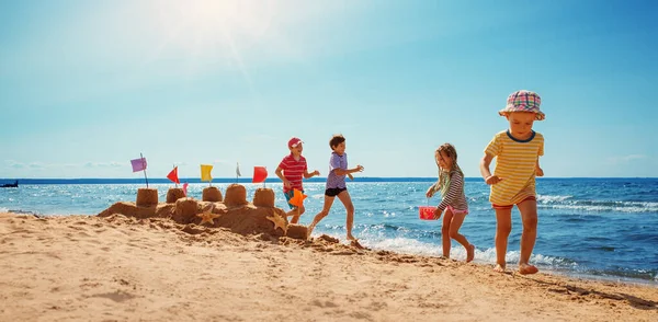 Niños felices de vacaciones en la playa corriendo en el agua — Foto de Stock