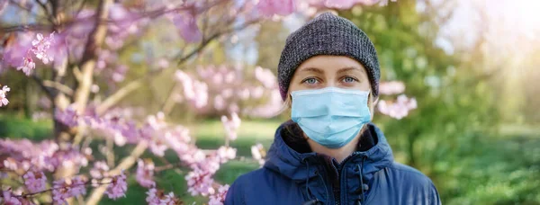 Mladá žena v lékařské ochranné masky venku v přírodě — Stock fotografie