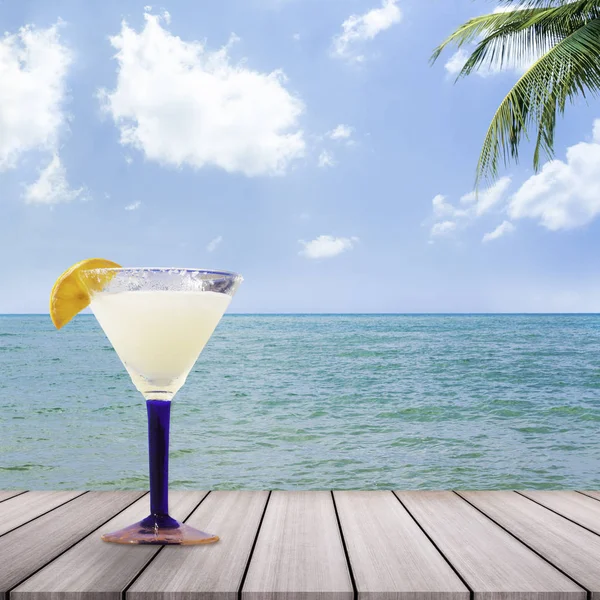 Cocktail glasses with sea background.