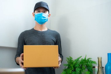 Koruyucu yüz maskesi takan teslimatçı.