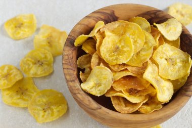 Kızarmış muz bir ahşap kase cips.