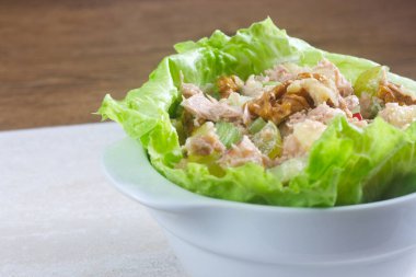 Kereviz, elma ve cevizden yapılmış ev yapımı Waldorf salatası resmi taze yaprak marulundan bir yatakta servis edilir..