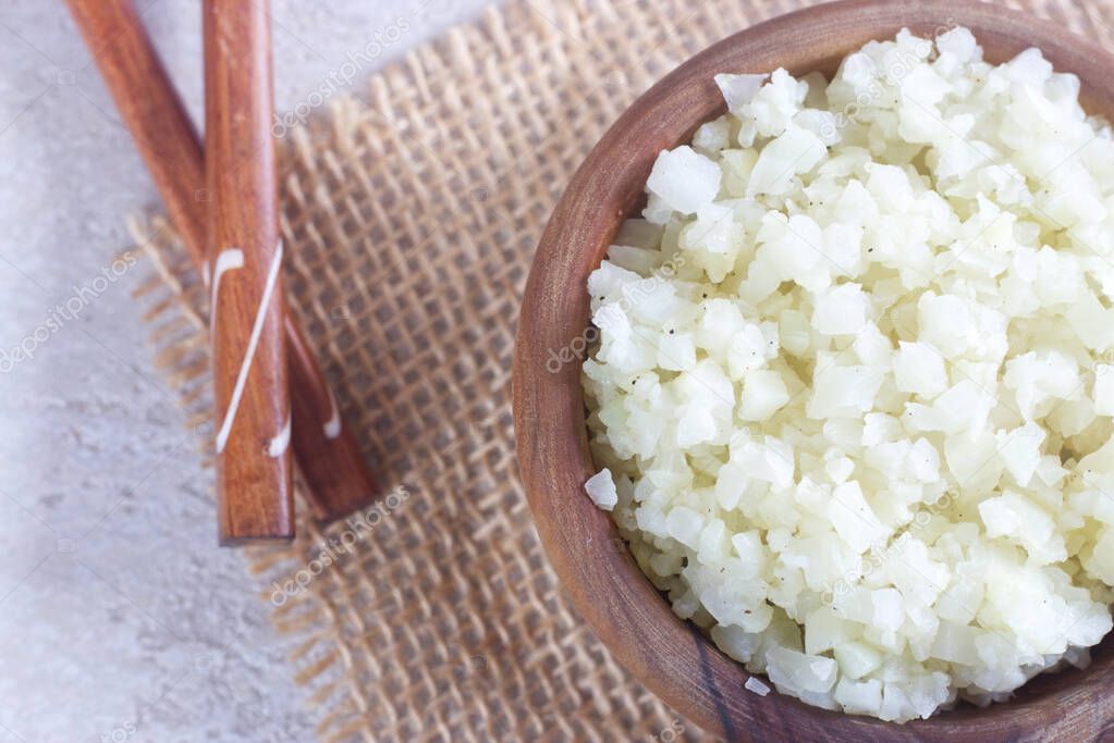 Photo of Homemade Healthy Vegetarian Cauliflower Rice in Wooden Bowl.