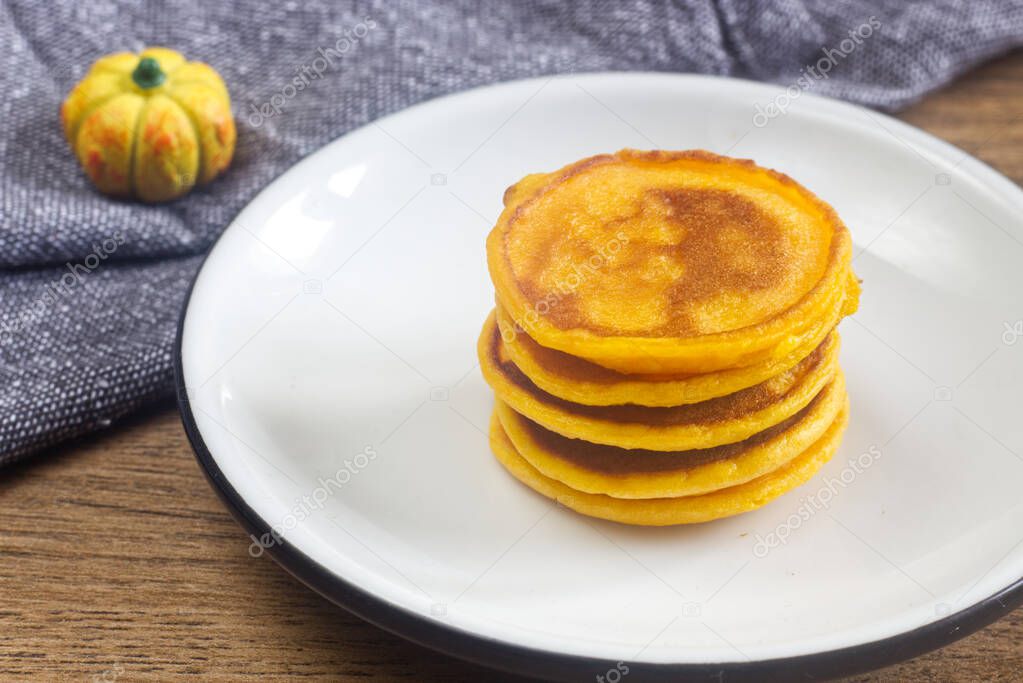 Photo of homemade pumpkin pancakes on the white plate.