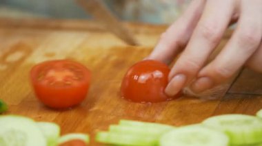 Ekstra bir kırmızı kiraz domates ahşap tahta üzerinde mutfak bıçak ile kesme yakın