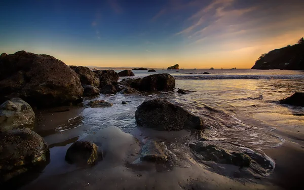 Paisaje de playa rocosa al atardecer —  Fotos de Stock